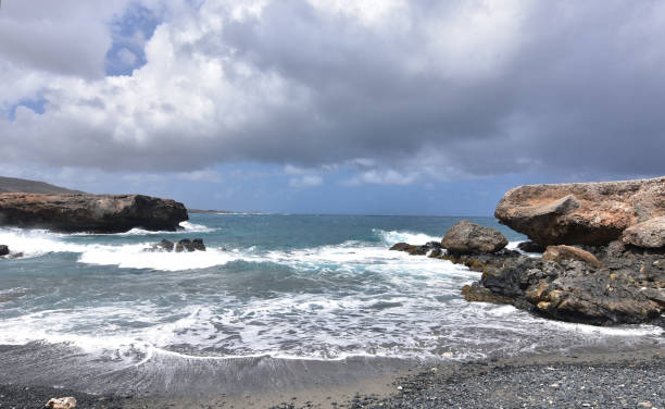 istock Stunning Black Sand Stone Beach in Aruba 1142664542