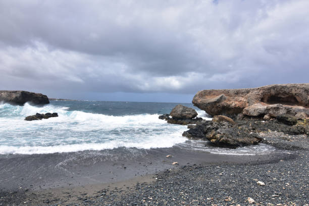 istock Stunning Black Sand Stone Beach in Aruba 1142664566