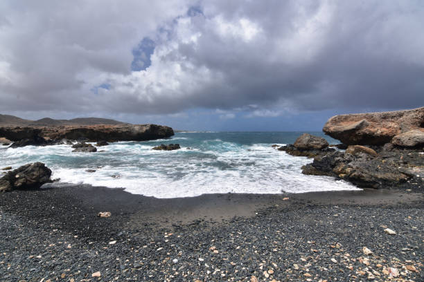 istock Stunning Black Sand Stone Beach in Aruba 1142664609
