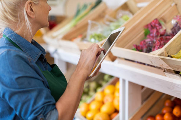 istock Shop assistant with digital tablet in small grocery store 1142665498