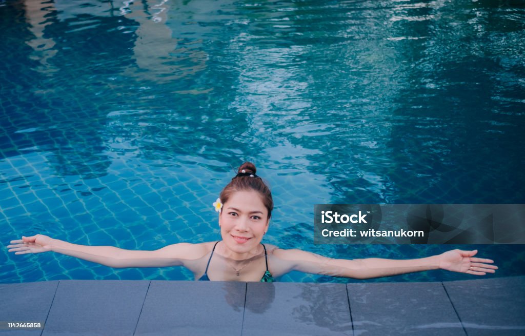 Joven Asia mujer feliz en la piscina. Resort en Tailandia. - Foto de stock de Actividades y técnicas de relajación libre de derechos