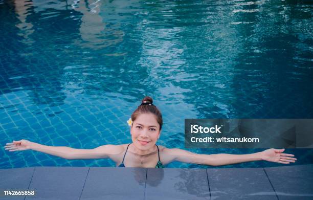 Joven Asia Mujer Feliz En La Piscina Resort En Tailandia Foto de stock y más banco de imágenes de Actividades y técnicas de relajación