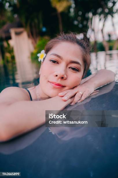 Joven Asia Mujer Feliz En La Piscina Resort En Tailandia Foto de stock y más banco de imágenes de Actividades y técnicas de relajación