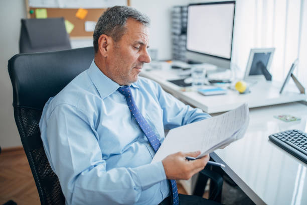 istock Senior businessman holding papers 1142666315