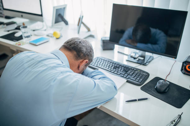 istock Overworked senior businessman sleeping at the office desk 1142666428