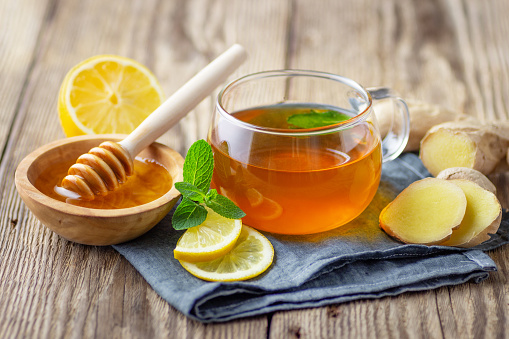 Una taza de té de cristal con limón, menta y jengibre photo