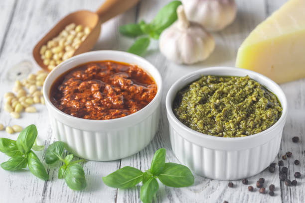 Bowls of classic and sun-dried tomato pesto Bowls of classic and sun-dried tomato pesto with ingredients on the white wooden background pecorino romano stock pictures, royalty-free photos & images