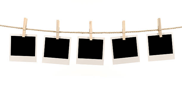 Blank polaroid pictures hanging on a clothes line Several blank instant photo prints hanging on a rope or washing line.   Alternative version of this file shown below: clothespin photos stock pictures, royalty-free photos & images