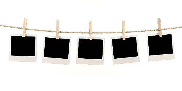 Several blank instant photo prints hanging on a rope or washing line.   Alternative version of this file shown below: