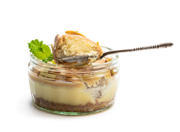 Mini caramel and almond cheesecake in a glass pot isolated on white background Mini  caramel and almond cheesecake in a glass pot isolated on white background cake jar stock pictures, royalty-free photos & images