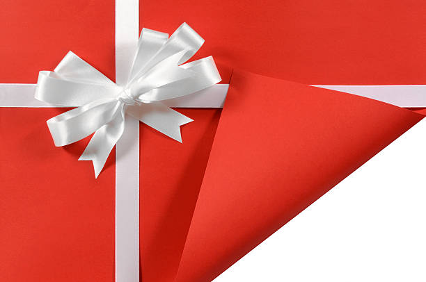 istock White gift ribbon on red paper with curled corner 114267288