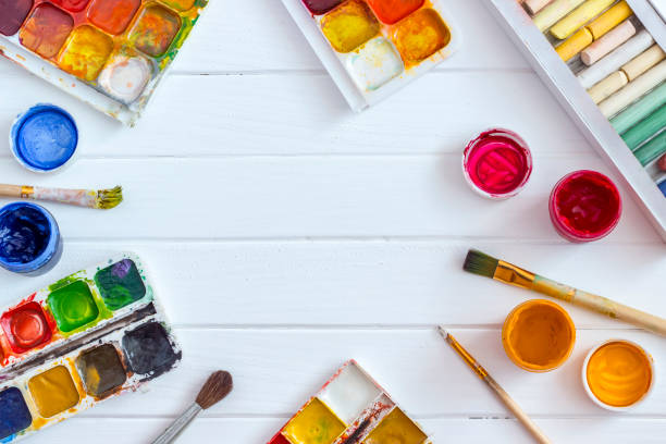 istock Old Paints and brushes on a white wooden background 1142673202