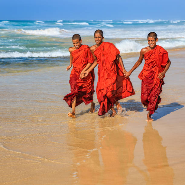 istock Sri Lankan young buddhist monks walking on the beach, Ceylon 1142674869