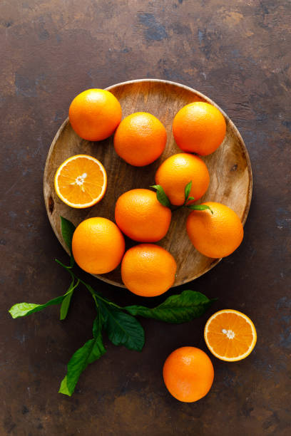 istock Oranges with leaves on dark background, top view 1142676008