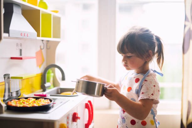 istock Little girl cooking on decorative kitchen at home. 1142678037