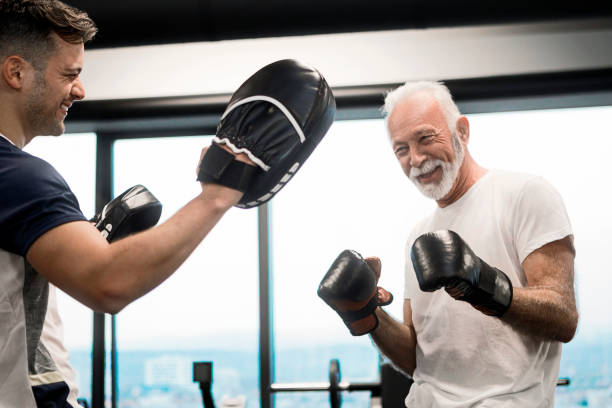 Senior Boxer giving his best Boxer in Training old man boxing stock pictures, royalty-free photos & images