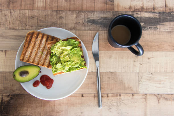 el desayuno con tostadas, aguacate y café - coffee whole wheat food bread fotografías e imágenes de stock