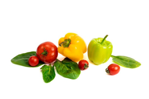istock Yellow and green feathers with tomatoes on a white background. Cherry tomatoes with greens and sweet peppers on a white background. Green pepper and yellow with tomatoes and herbs on a white background. 1142680418