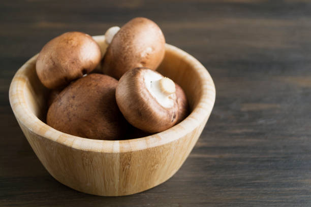 istock Fresh king brown mushrooms on wooden background. 1142681999