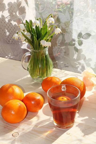 istock Tea in a cup, primroses and lemon on a sunny table. 1142687323
