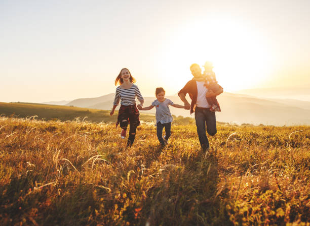 幸せな家族: 日没の母、父、子供の息子と娘 - child dancing ethnic outdoors ストックフォトと画像
