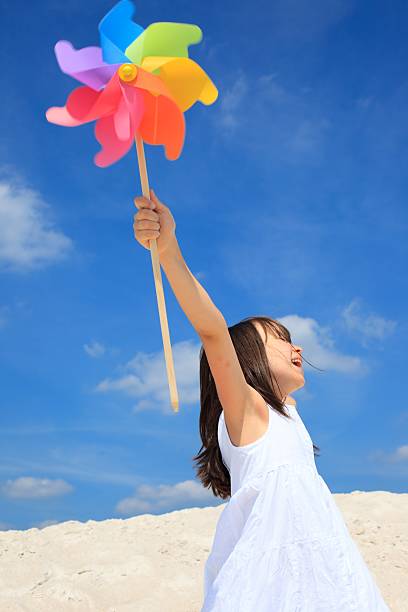 istock Girl with pinwheel on beach 114269067