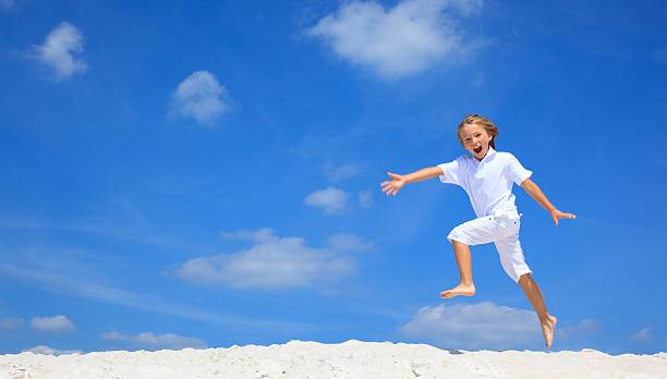 istock Happy boy jumping on beach 114269081