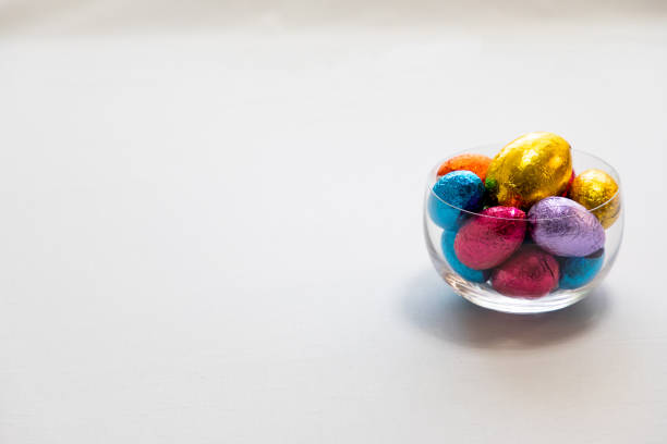 istock Colorful chocolate easter eggs in a transparent bowl isolated with whit background 1142697720