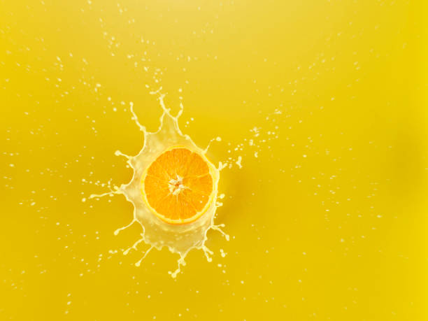 Slice of Orange falling into Orange juice