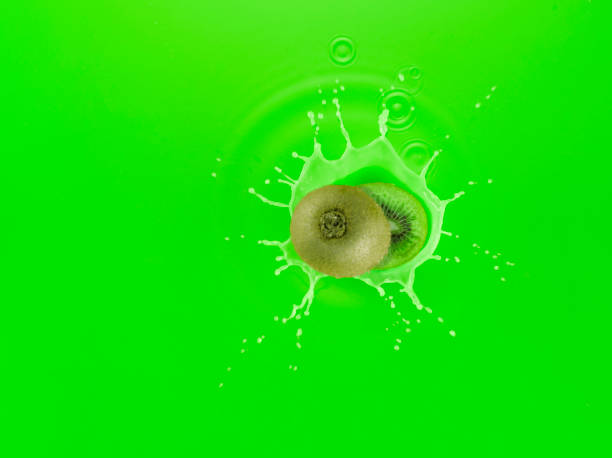 Ripe Kiwi fruit falling into Kiwi Juice