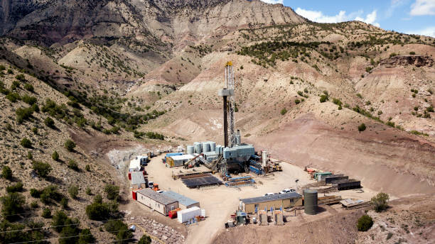 clip drone aerea di un carro di perforazione di fracking sulle colline del colorado in primavera - drilling equipment foto e immagini stock