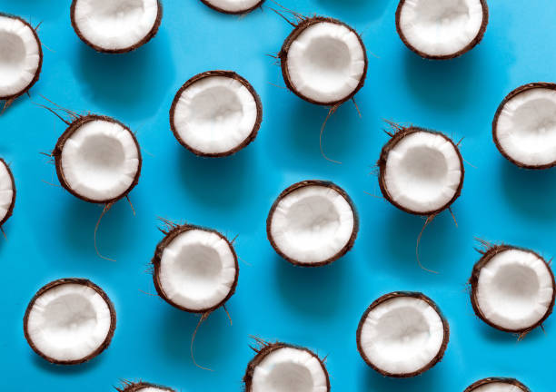 istock Broken Coconut isolated on a blue background. Border design. Fresh raw organic half of coco nut 1142702996