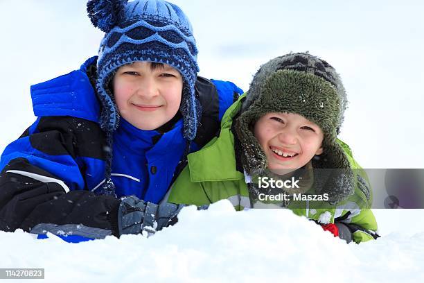 Niños Jugando En La Nieve Foto de stock y más banco de imágenes de Accesorio de cabeza - Accesorio de cabeza, Aire libre, Alegre
