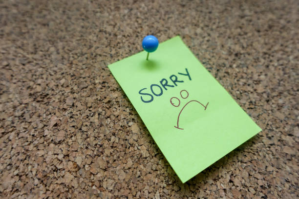 istock Green Sticky Note With Sorry Message And Blue Push Pin On Cork board 1142709343