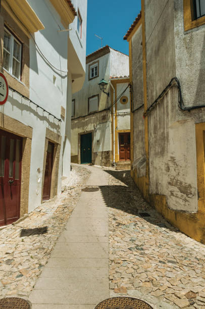 istock Old houses with whitewashed wall in cobblestone alley 1142709358