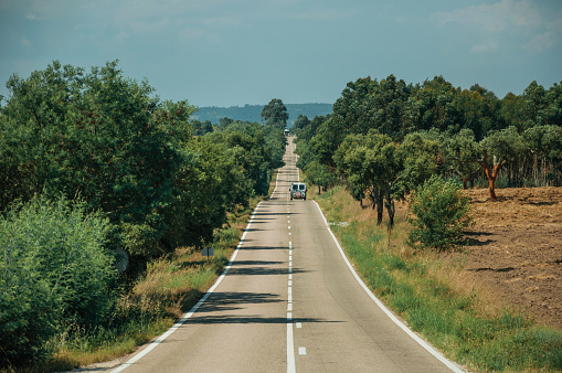 Carretera con coche solitario a través del paisaje rural y los árboles photo
