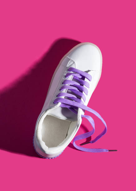 istock White sneaker with purple laces on pink 1142712226