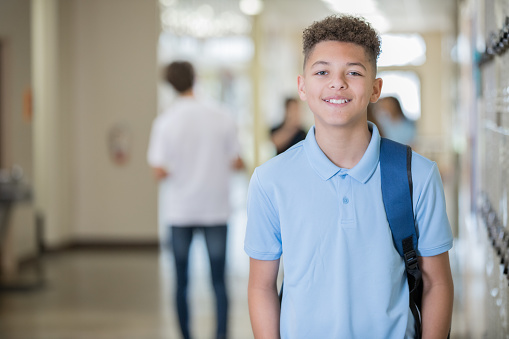 Teen male standing in hallway at school
