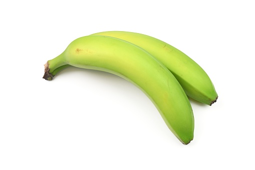 A close up view of a bunch of green bananas.  The  two bananas are not yet ripe enough to eat.  Isolated on a white background.