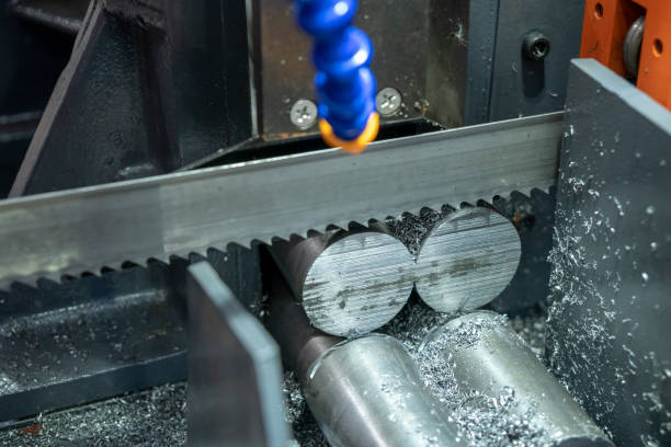 The  band saw machine cutting raw metals rods .The industrial sawing machine cutting the material rod.