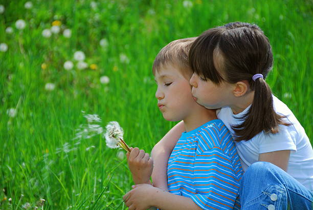 istock Kids blowing dandelion seeds 114273196