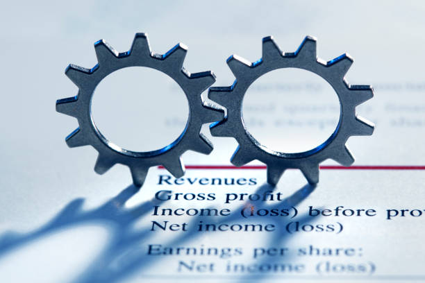 istock Two Interlocking Gears On Top Of A Financial Report 1142734159