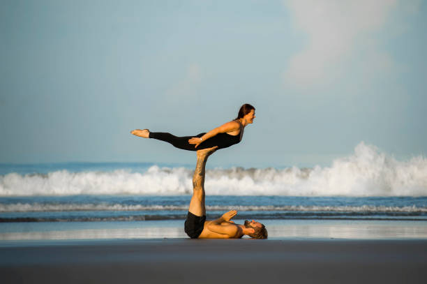 istock young attractive and beautiful acrobat couple practicing acroyoga exercise concentrated keeping balance practicing yoga on the beach in relaxation and meditation concept and healthy lifestyle 1142740857