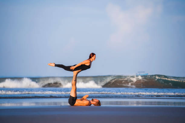istock young attractive and beautiful acrobat couple practicing acroyoga exercise concentrated keeping balance practicing yoga on the beach in relaxation and meditation concept and healthy lifestyle 1142740863