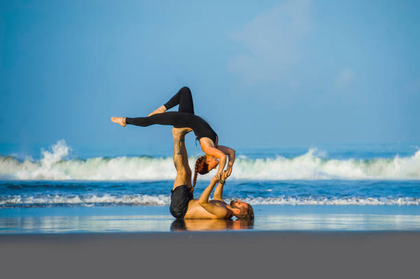 istock young attractive and beautiful acrobat couple practicing acroyoga exercise concentrated keeping balance practicing yoga on the beach in relaxation and meditation concept and healthy lifestyle 1142740945