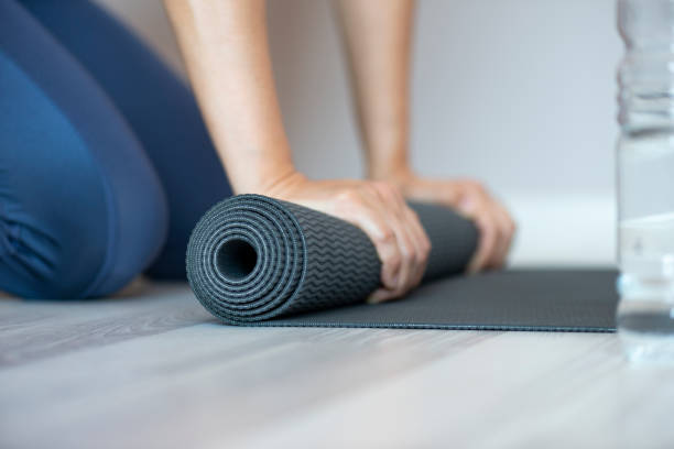 istock Woman Rolling Yoga Mat 1142742262