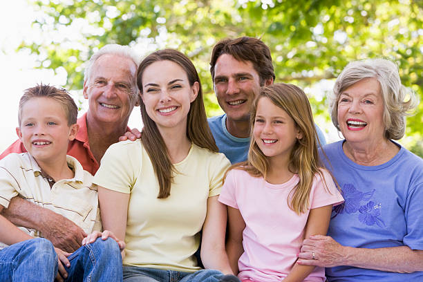 istock Extended family sitting outdoors smiling 114274235