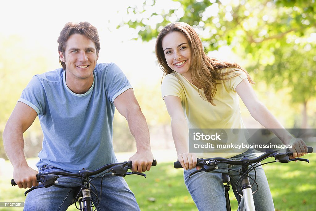 Couple on bikes outdoors smiling  20-29 Years Stock Photo
