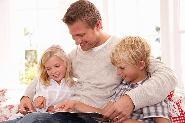istock Father and children reading together 114274260