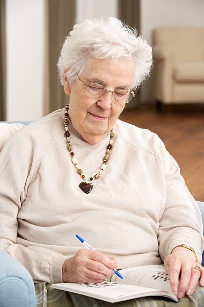 istock Senior Woman Relaxing At Home Completing Crossword 114274351